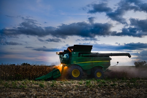 Harvester working a field at dusk